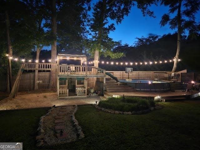 back of house featuring a fenced in pool, a playground, a yard, and a fenced backyard