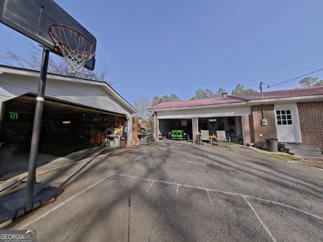 view of property exterior with entry steps, brick siding, and an outdoor structure