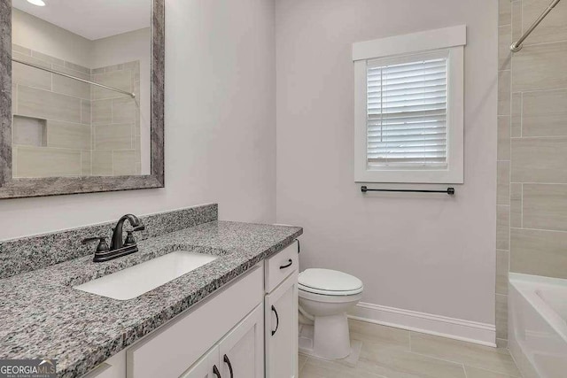 bathroom featuring vanity, toilet, and baseboards