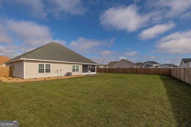 back of house featuring a fenced backyard and a lawn