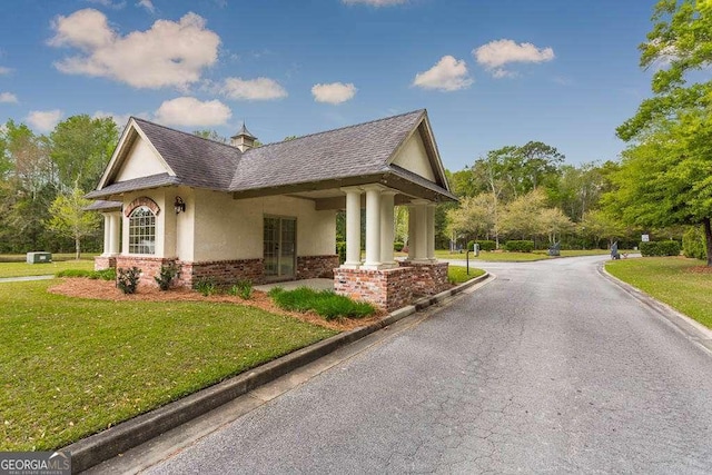 view of home's exterior featuring brick siding, a chimney, stucco siding, a shingled roof, and a lawn