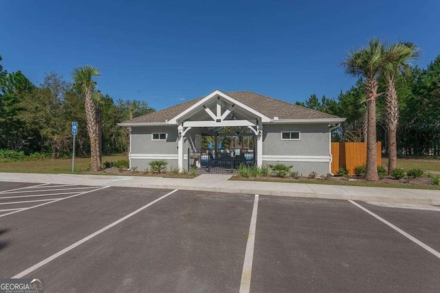 view of property with uncovered parking and fence