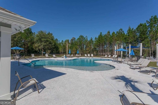 community pool featuring a patio and fence