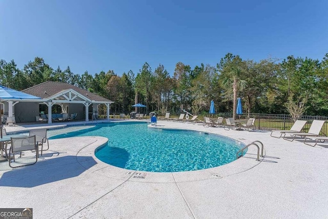 pool featuring a patio area and fence