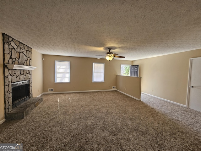 unfurnished living room featuring a fireplace, carpet flooring, a ceiling fan, visible vents, and baseboards