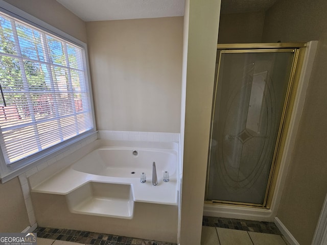 full bathroom with a garden tub, tile patterned flooring, and a shower stall