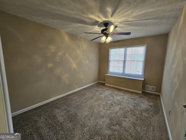 empty room with carpet floors, visible vents, ceiling fan, a textured ceiling, and baseboards