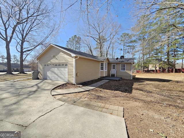 ranch-style house with concrete driveway and an attached garage