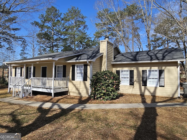 view of front of property with crawl space, a porch, and a chimney