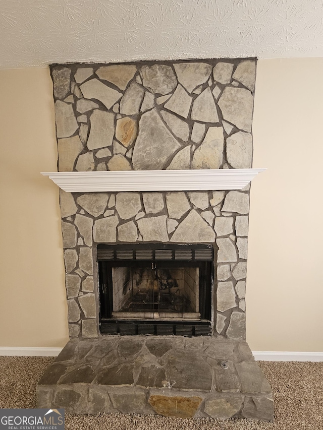 interior details with carpet, baseboards, a stone fireplace, and a textured ceiling