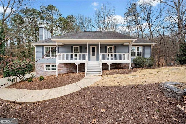 single story home featuring a chimney and a porch