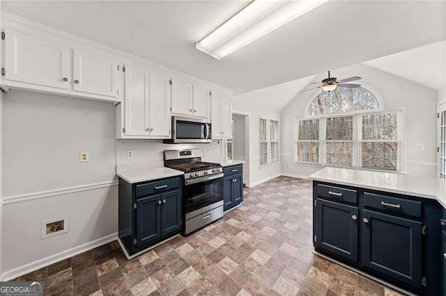 kitchen featuring blue cabinetry, white cabinetry, stainless steel appliances, and light countertops