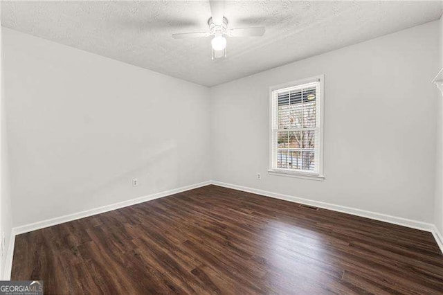 spare room with visible vents, baseboards, dark wood finished floors, ceiling fan, and a textured ceiling