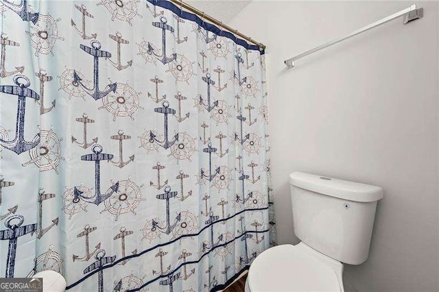 bathroom featuring a shower with shower curtain and toilet