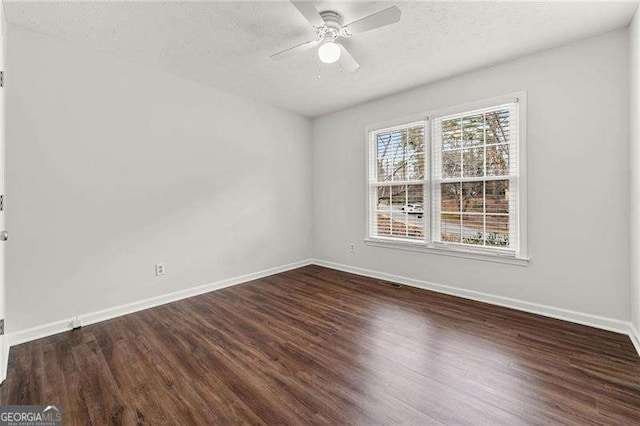 empty room featuring a ceiling fan, a textured ceiling, baseboards, and wood finished floors