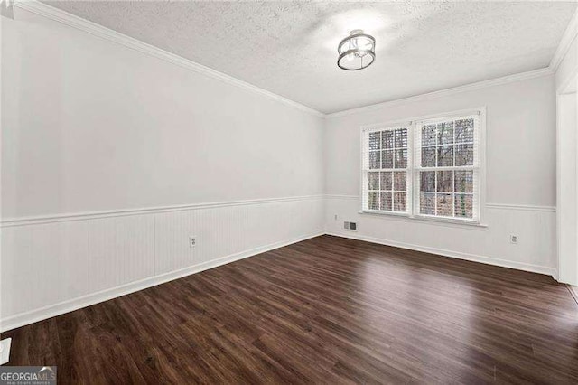 unfurnished room with a wainscoted wall, a textured ceiling, and wood finished floors