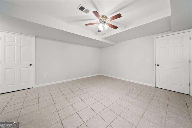 unfurnished room with ceiling fan, light tile patterned floors, visible vents, and baseboards