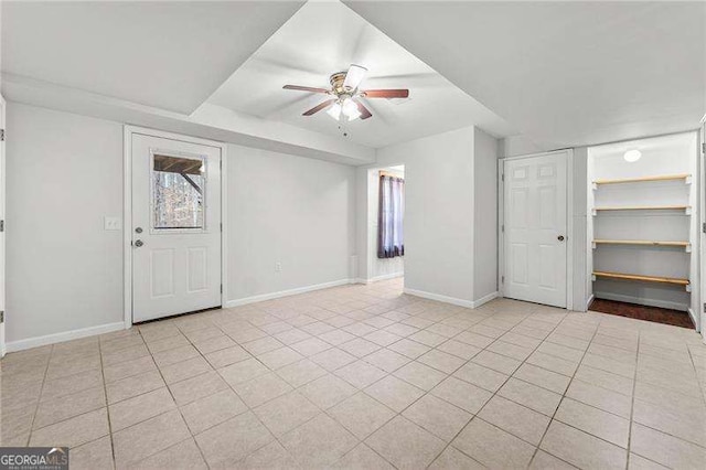 interior space featuring light tile patterned floors, baseboards, and a ceiling fan