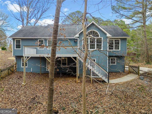 rear view of property with stairs, fence, and a wooden deck