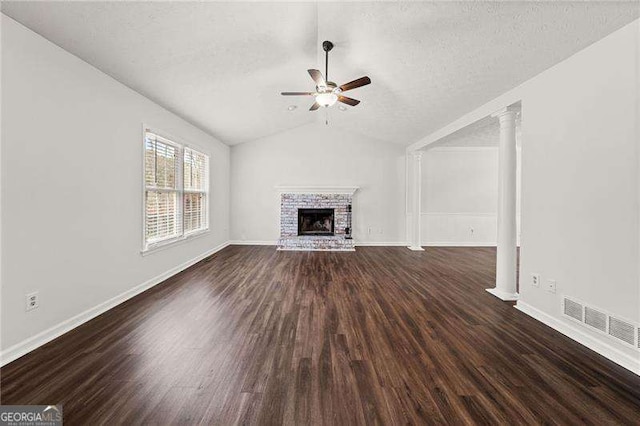 unfurnished living room with dark wood-style flooring, a brick fireplace, visible vents, and a ceiling fan