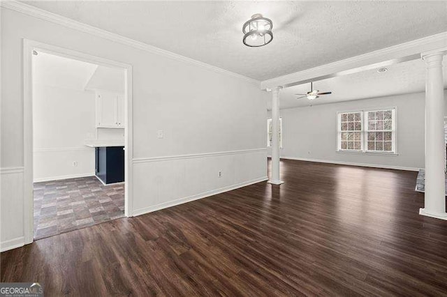 interior space featuring crown molding, a ceiling fan, dark wood-type flooring, a textured ceiling, and ornate columns