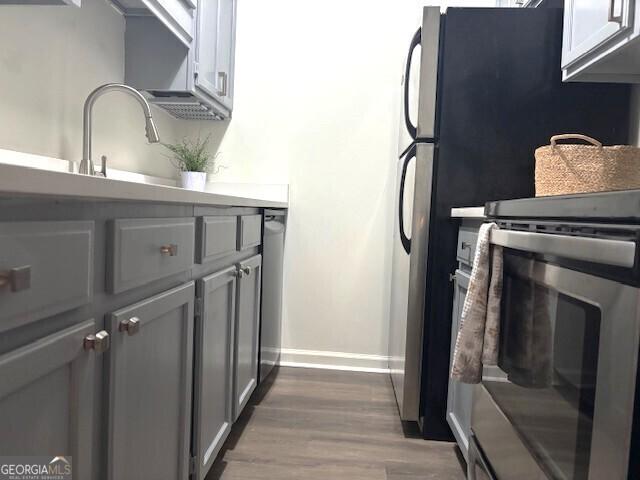 32 Peachtree St Unit 202, Atlanta, GA 30303 - kitchen with range, baseboards, dark wood finished floors, and a sink