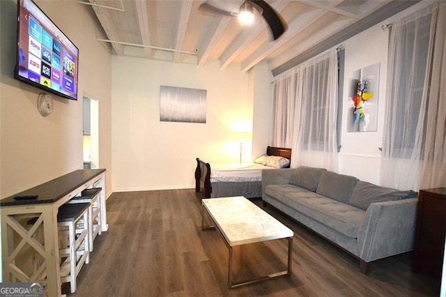 living area featuring dark wood-style floors, beamed ceiling, and baseboards