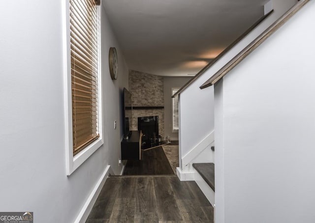 hall featuring baseboards, stairway, and wood finished floors