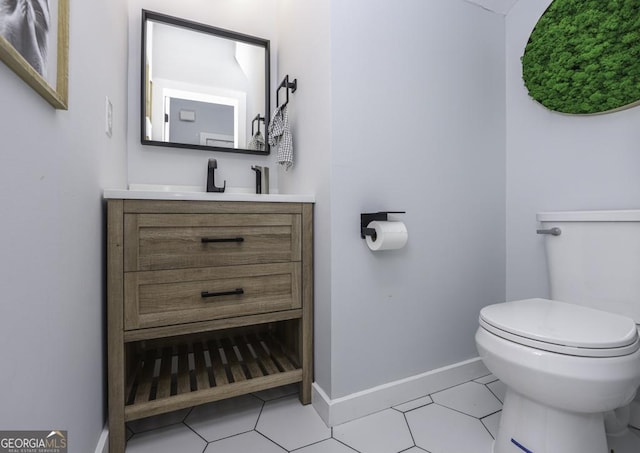 half bath featuring tile patterned flooring, baseboards, vanity, and toilet