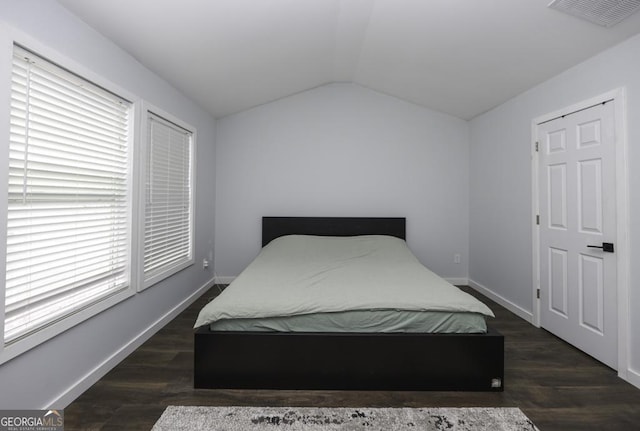 bedroom featuring lofted ceiling, dark wood-style flooring, visible vents, and baseboards