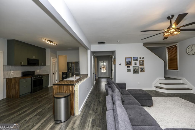 kitchen with tasteful backsplash, visible vents, dark wood-style floors, black appliances, and a sink