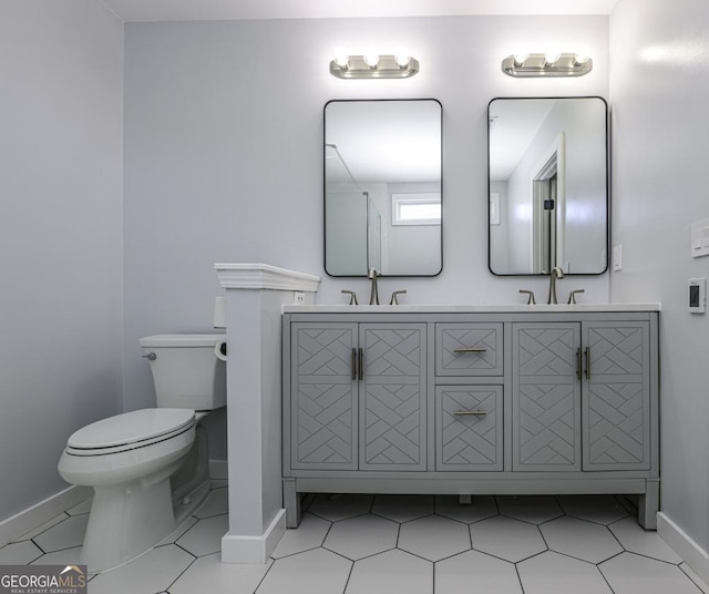 bathroom featuring tile patterned flooring, baseboards, a sink, and toilet