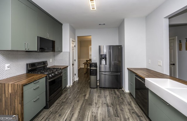 kitchen featuring visible vents, dark wood finished floors, butcher block countertops, appliances with stainless steel finishes, and backsplash