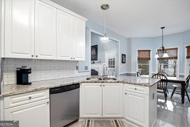 kitchen featuring a sink, tasteful backsplash, stainless steel dishwasher, a peninsula, and white cabinets