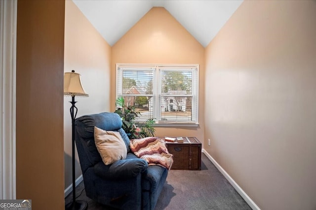 living area featuring carpet flooring, baseboards, and vaulted ceiling