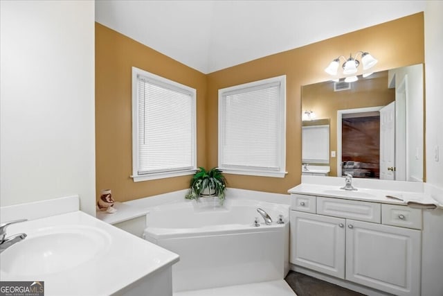 bathroom with a garden tub, two vanities, ensuite bathroom, and a sink