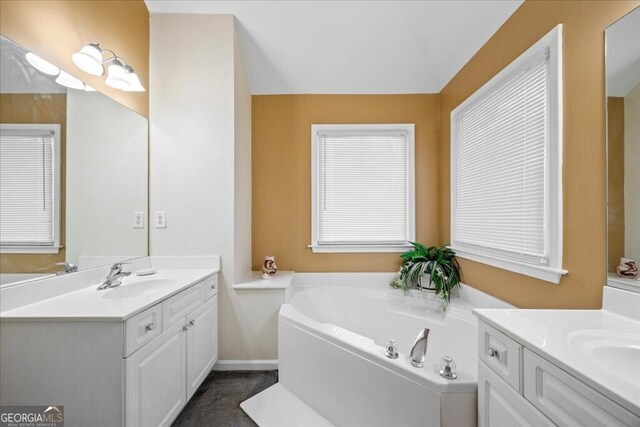 full bath with a bath, two vanities, and a sink