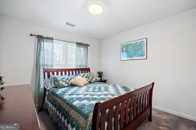 carpeted bedroom featuring baseboards and visible vents