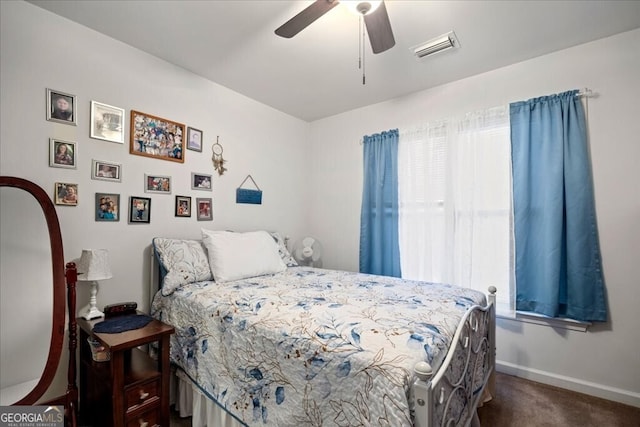 bedroom featuring visible vents, dark carpet, a ceiling fan, and baseboards