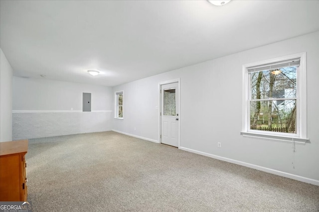 spare room featuring electric panel, baseboards, and carpet floors