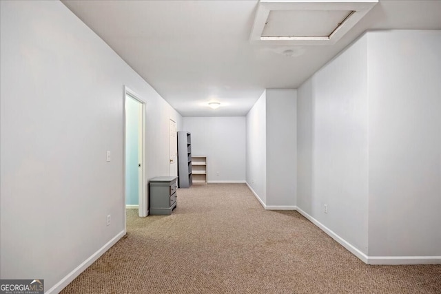 corridor with baseboards, carpet, and attic access