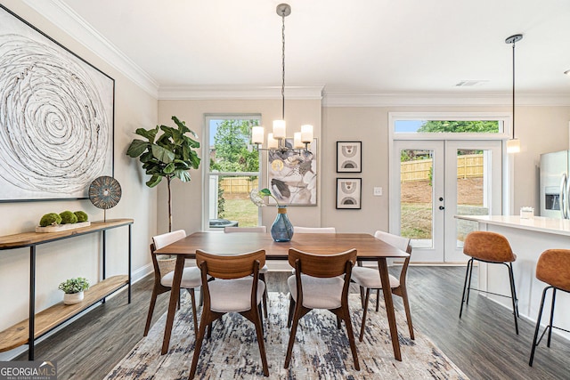 dining space featuring ornamental molding, french doors, a chandelier, and dark wood finished floors