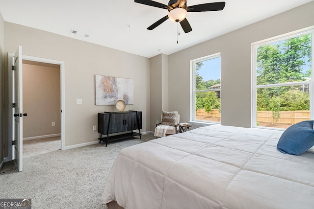 carpeted bedroom with a ceiling fan, visible vents, and baseboards