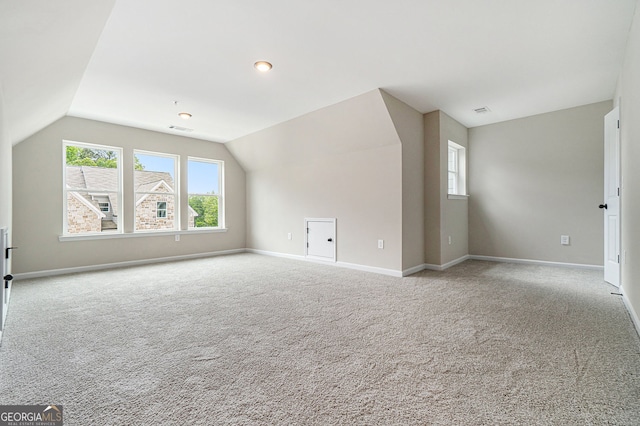 additional living space featuring vaulted ceiling, carpet, visible vents, and baseboards