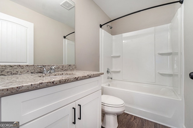 bathroom featuring visible vents, toilet, vanity, wood finished floors, and shower / bathtub combination