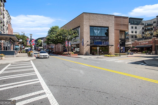 view of street featuring street lighting, traffic signs, curbs, and sidewalks