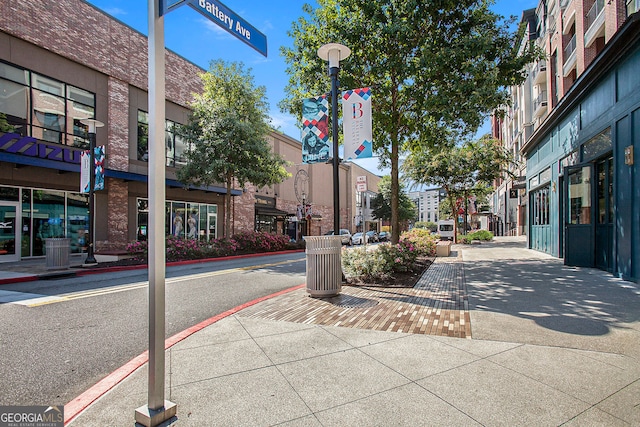 view of road with street lighting, traffic signs, curbs, and sidewalks