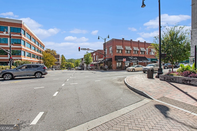 view of road featuring curbs, street lighting, traffic lights, and sidewalks