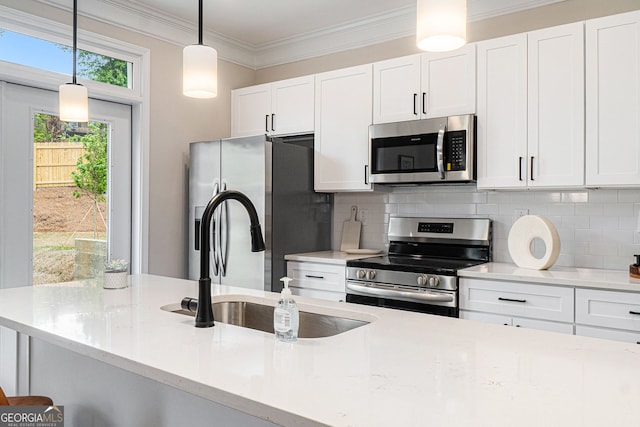 kitchen with hanging light fixtures, decorative backsplash, stainless steel appliances, and crown molding