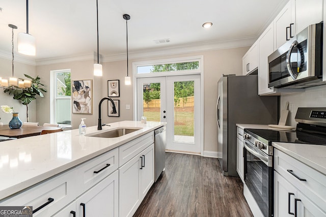 kitchen with white cabinetry, appliances with stainless steel finishes, a sink, and ornamental molding